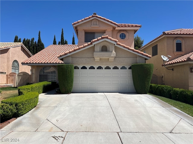 mediterranean / spanish home featuring a garage