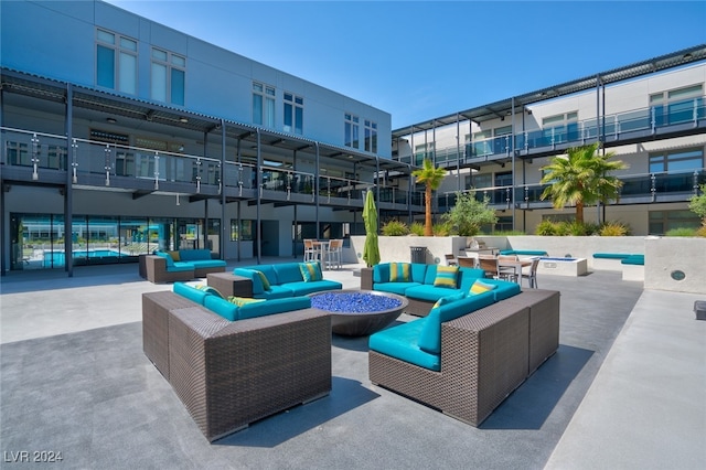 view of patio with an outdoor living space with a fire pit