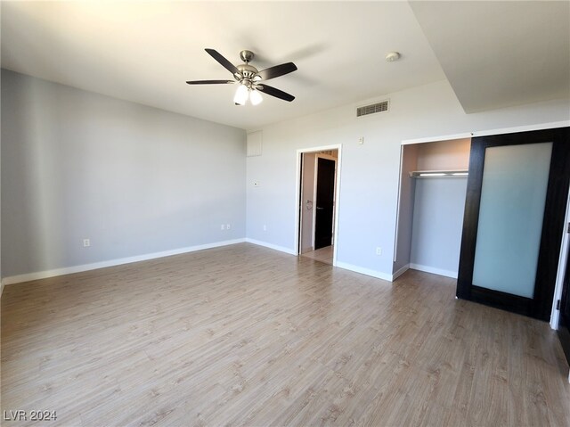 unfurnished bedroom with ceiling fan, a closet, and light hardwood / wood-style floors