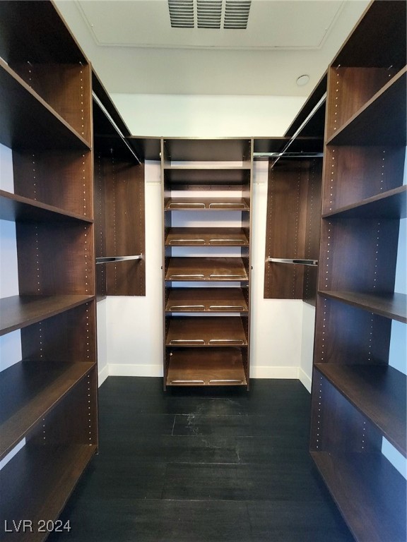 spacious closet featuring dark hardwood / wood-style floors