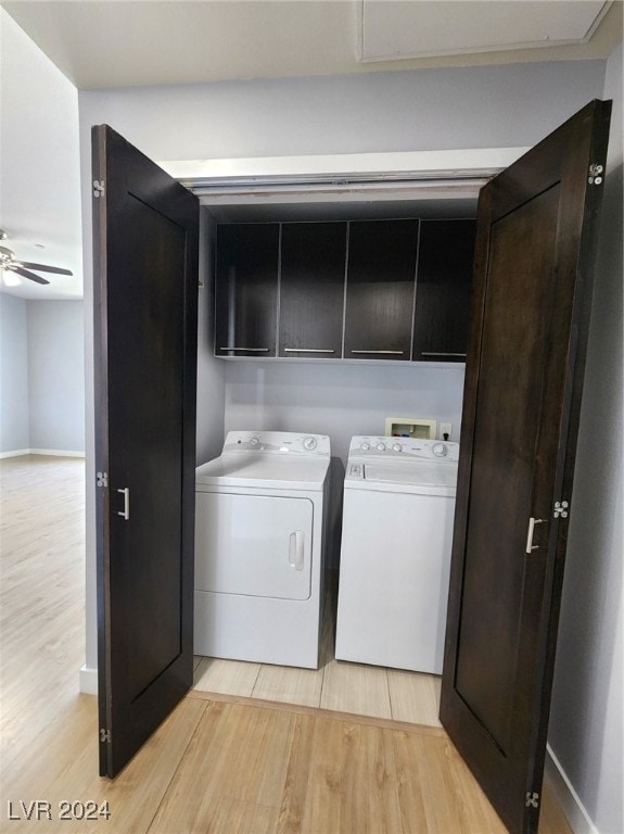 clothes washing area with washer and dryer, ceiling fan, cabinets, and light hardwood / wood-style flooring