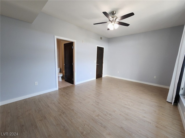 unfurnished bedroom featuring ensuite bathroom, ceiling fan, and light wood-type flooring