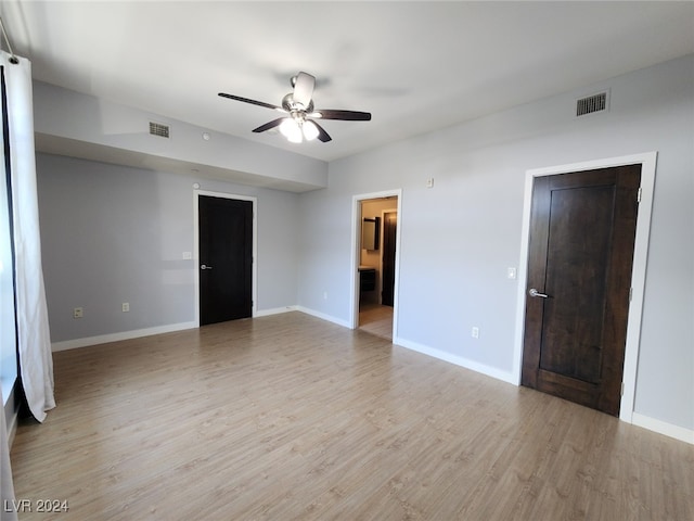 empty room with ceiling fan and light hardwood / wood-style floors