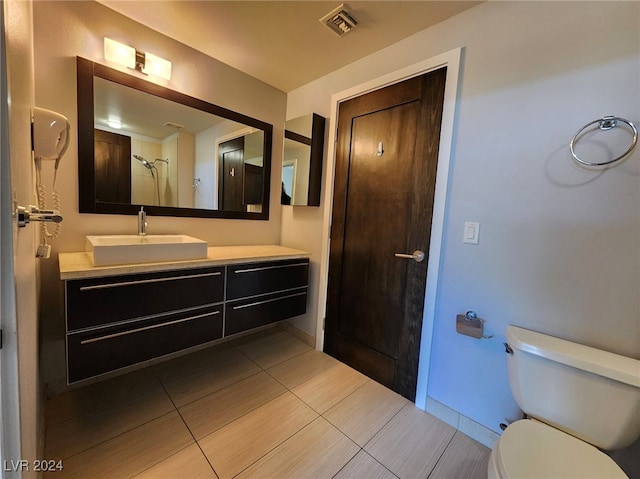 bathroom with tile patterned flooring, vanity, and toilet