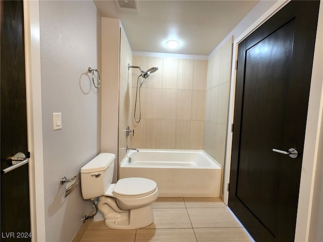 bathroom featuring tile patterned flooring, toilet, and tiled shower / bath