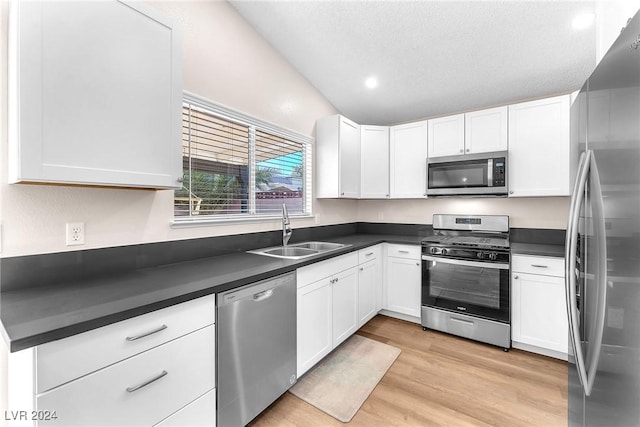 kitchen featuring appliances with stainless steel finishes, white cabinetry, and sink