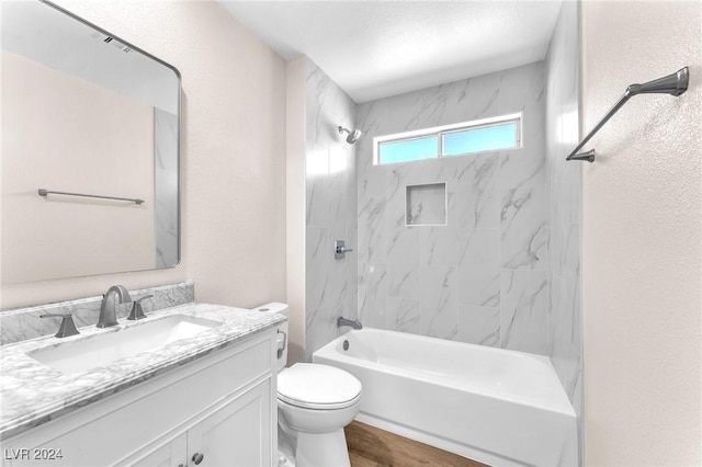 full bathroom featuring toilet, vanity, hardwood / wood-style floors, and tiled shower / bath