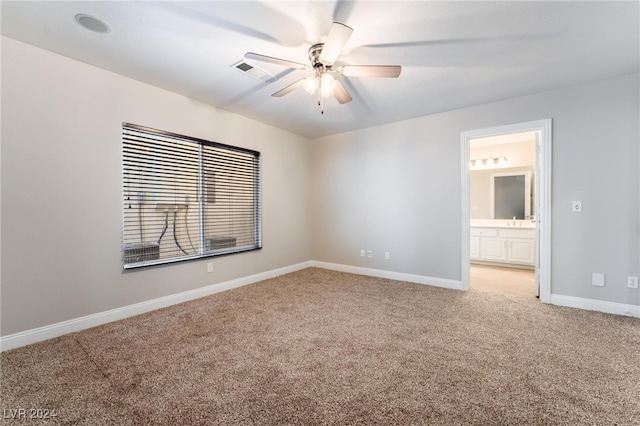 unfurnished room with light carpet, sink, and ceiling fan