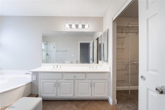 bathroom with a washtub, vanity, and tile patterned floors