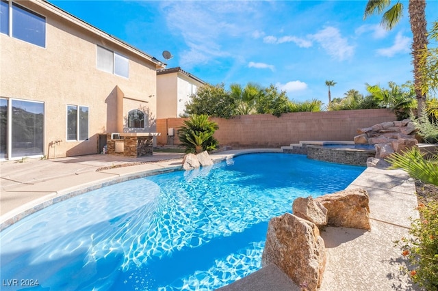 view of swimming pool featuring exterior kitchen, an in ground hot tub, and a patio