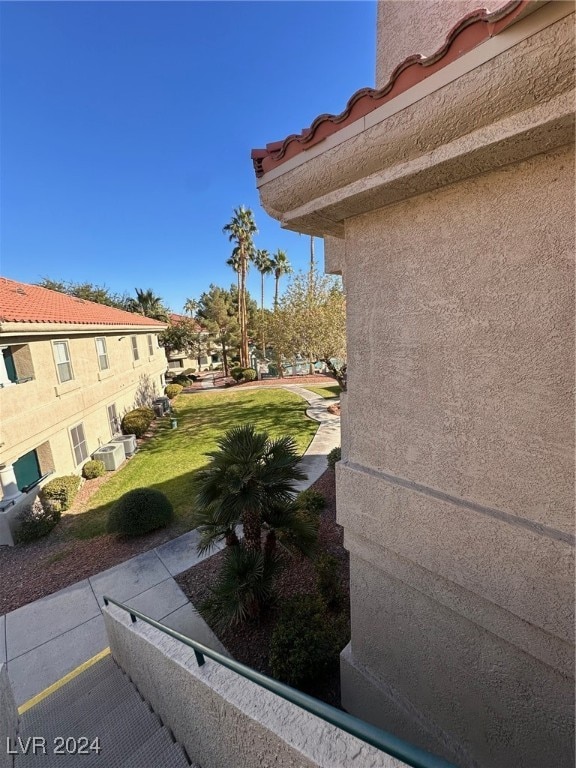 view of side of home featuring central air condition unit and a yard