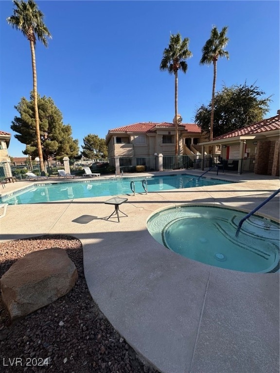 view of swimming pool with a hot tub and a patio area