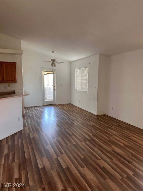 unfurnished living room featuring ceiling fan and dark hardwood / wood-style floors