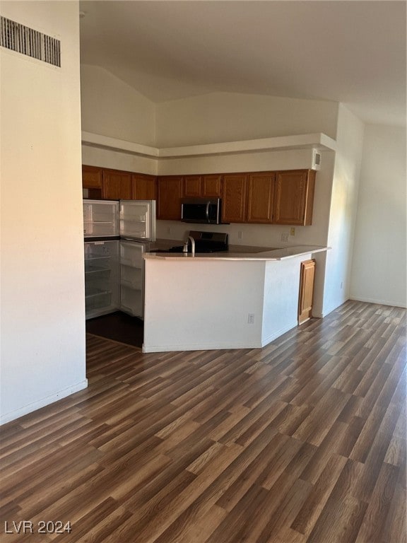 kitchen featuring kitchen peninsula, dark hardwood / wood-style floors, and high vaulted ceiling