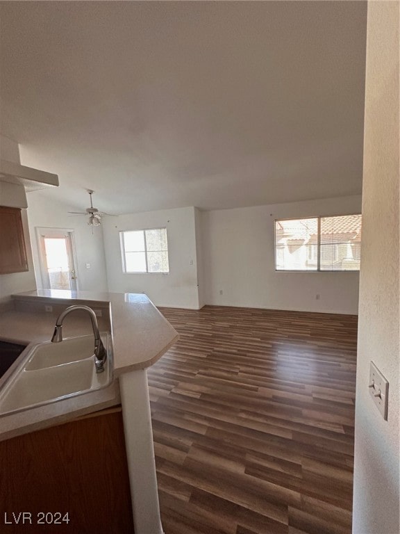 kitchen with ceiling fan, dark hardwood / wood-style flooring, kitchen peninsula, and sink