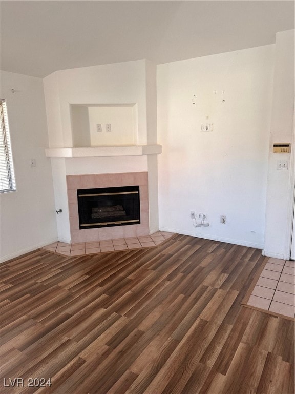 unfurnished living room featuring a fireplace and dark hardwood / wood-style flooring