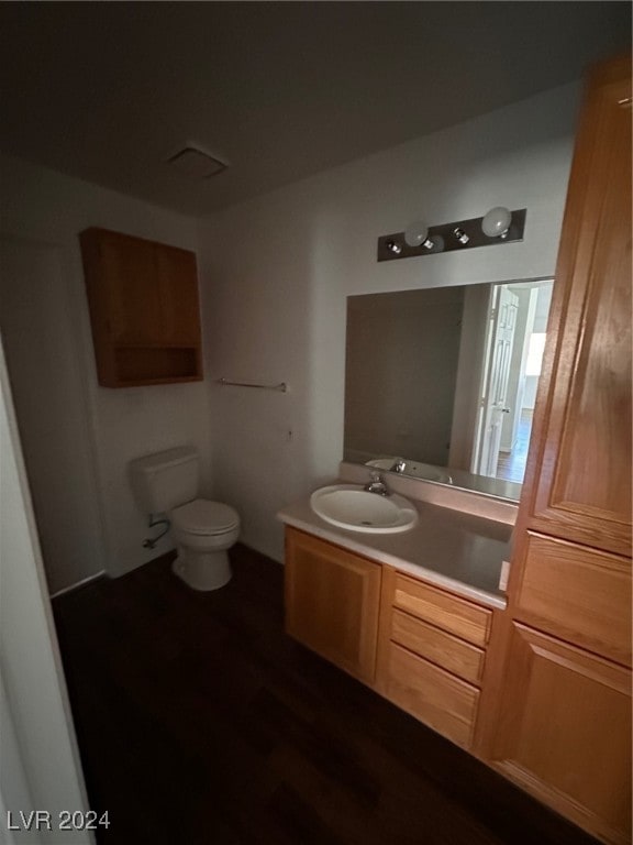 bathroom featuring hardwood / wood-style floors, vanity, and toilet