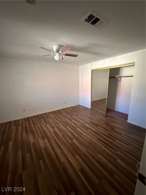 unfurnished bedroom featuring a closet, dark wood-type flooring, and ceiling fan