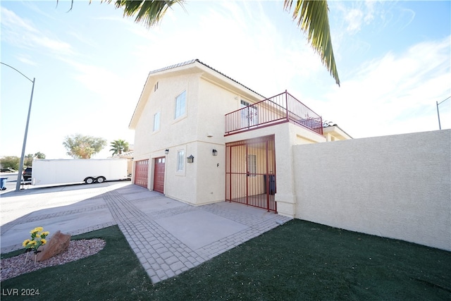 back of house featuring a balcony and a garage