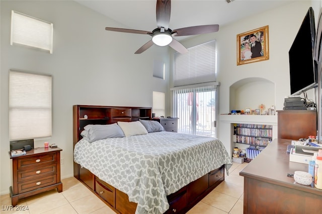 bedroom featuring ceiling fan, light tile patterned floors, and a towering ceiling