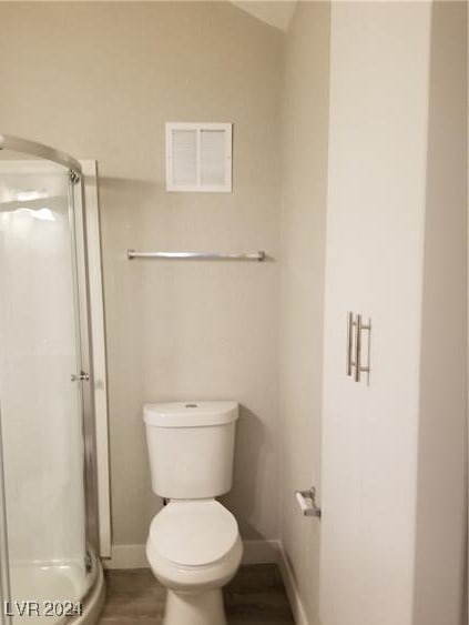 bathroom featuring an enclosed shower and toilet