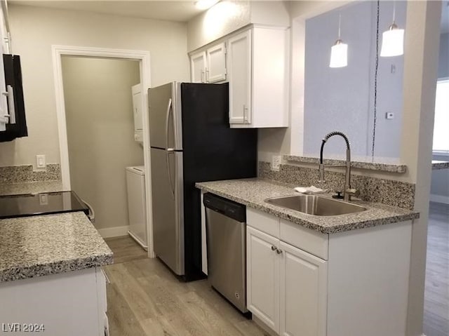 kitchen featuring light wood-type flooring, stainless steel dishwasher, sink, pendant lighting, and white cabinetry