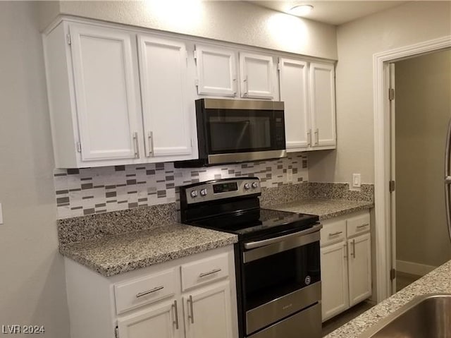 kitchen with white cabinetry, decorative backsplash, light stone countertops, and appliances with stainless steel finishes