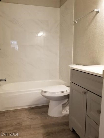 full bathroom featuring hardwood / wood-style flooring, vanity, toilet, and tiled shower / bath combo