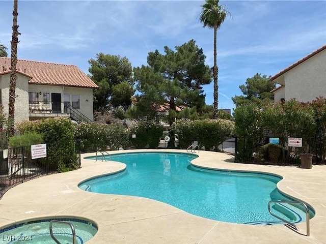 view of swimming pool with a community hot tub and a patio area