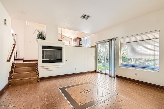 unfurnished living room featuring wood-type flooring and vaulted ceiling