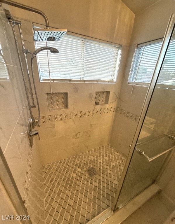 bathroom featuring tiled shower and a wealth of natural light