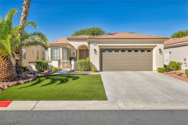 mediterranean / spanish-style home with a garage and a front lawn