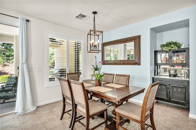 dining space with light tile patterned floors and a notable chandelier