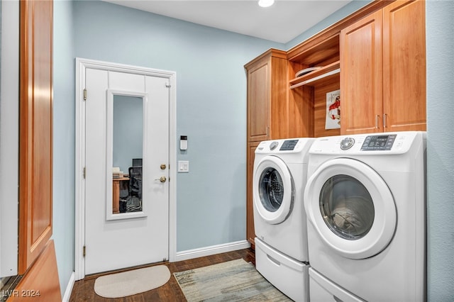 laundry area featuring washer and dryer, cabinets, and dark wood-type flooring