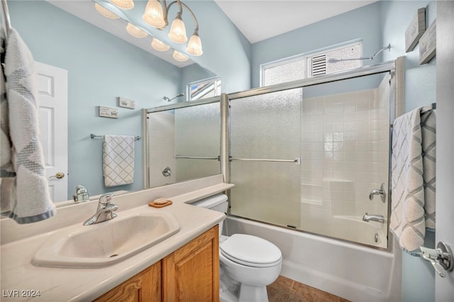 full bathroom with shower / bath combination with glass door, tile patterned flooring, vanity, and toilet