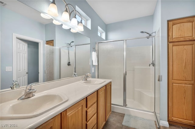 bathroom featuring tile patterned floors, vanity, and a shower with door