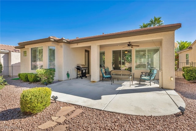 rear view of property with ceiling fan and a patio