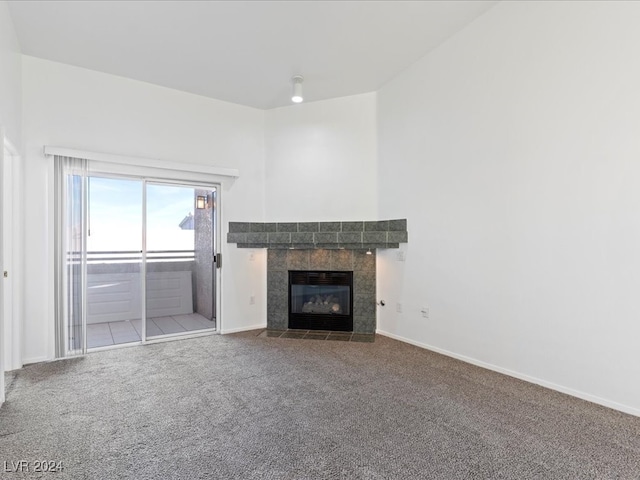 unfurnished living room featuring carpet floors and a tiled fireplace