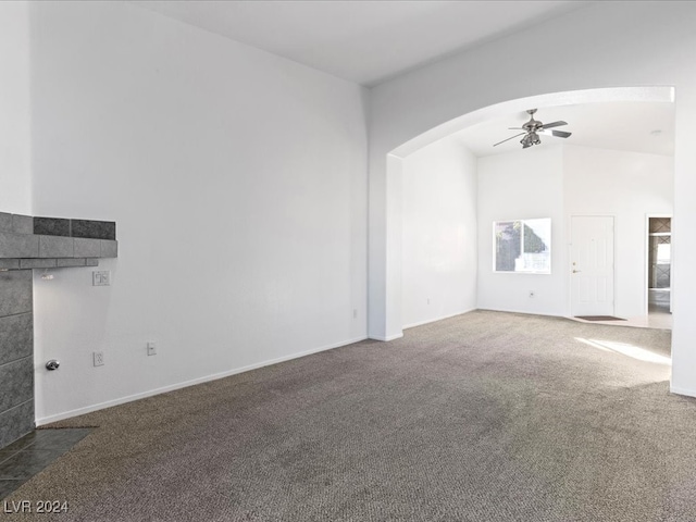 unfurnished living room featuring dark colored carpet and ceiling fan