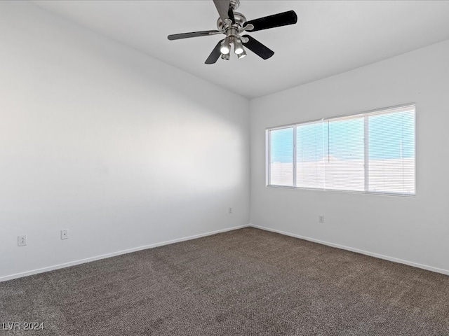 spare room featuring ceiling fan and dark carpet