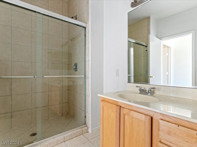 bathroom featuring tile patterned flooring, vanity, and walk in shower