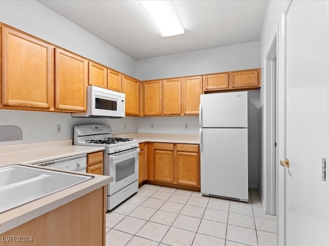 kitchen with white appliances, sink, and light tile patterned floors