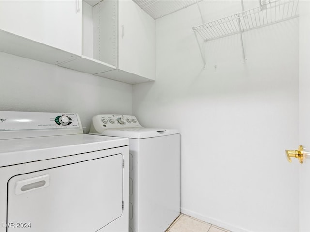 clothes washing area with independent washer and dryer and light tile patterned floors