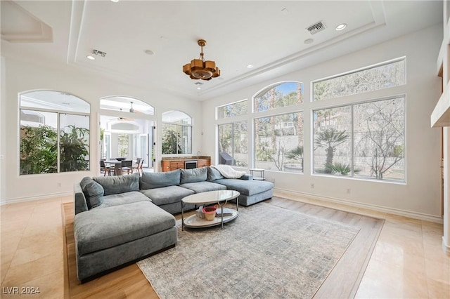 living room featuring a tray ceiling and light hardwood / wood-style floors