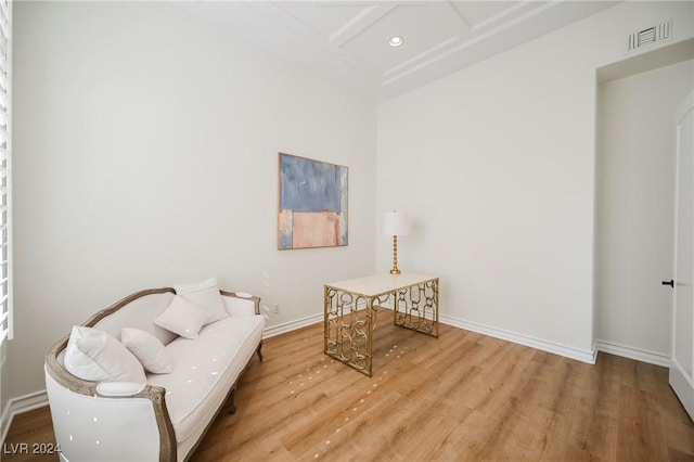 sitting room with coffered ceiling and light hardwood / wood-style floors