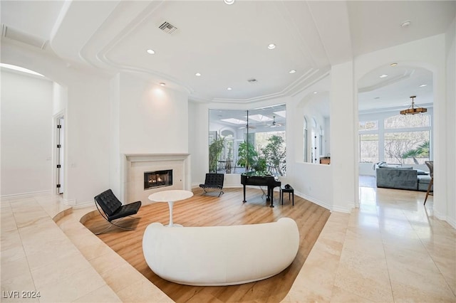 tiled living room with ornamental molding and ceiling fan