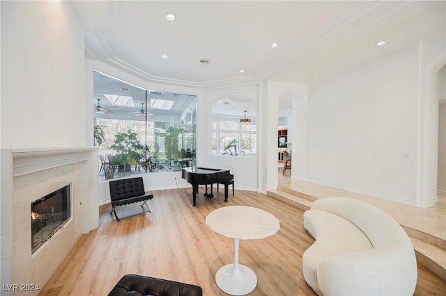 living area with crown molding, hardwood / wood-style flooring, and ceiling fan