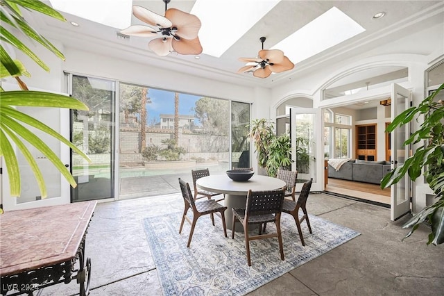 sunroom featuring plenty of natural light, ceiling fan, and a skylight