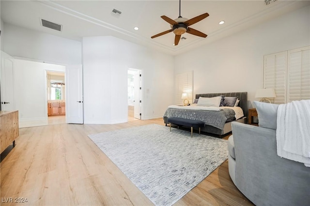 bedroom with ensuite bath, light hardwood / wood-style floors, and ceiling fan