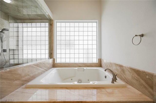 bathroom with plenty of natural light and separate shower and tub